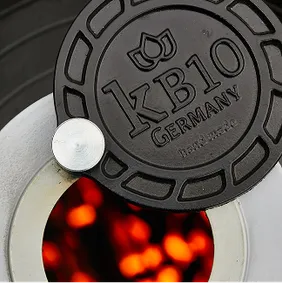 Nahaufnahme des KB10 Germany Gussdeckels über glühender Holzkohle