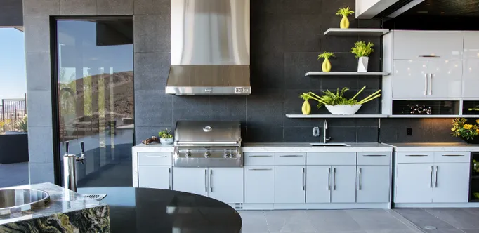 Terrasse mit einer FireMagic Outdoorküche mit weißen Fronten und silbernen Metallgriffen