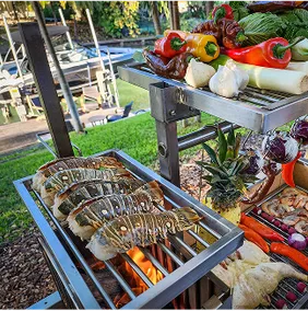 Frisches Gemüse und Fleisch auf einem Tagwood Grill, bereit zum Grillen.